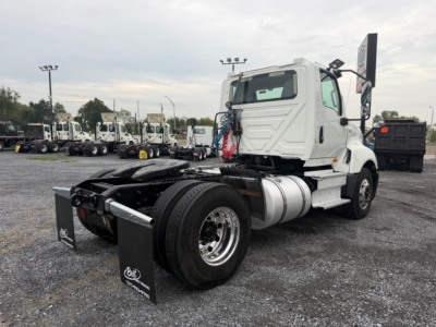 Truck rear chassis and cab of an International LT625 conventional daycab showing fuel tanks and dual rear tires.
