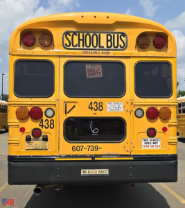 Rear view of a yellow 2017 Blue Bird Vision school bus showing School Bus sign, emergency door, rear lights, and bus number 438.
