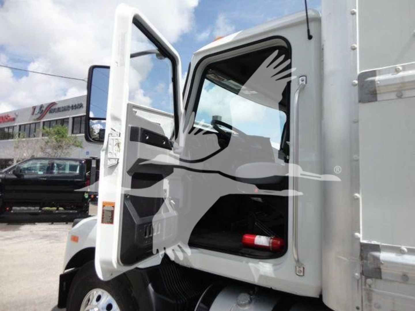 Box truck cab with door open showing interior and dashboard; no detailed labels visible.