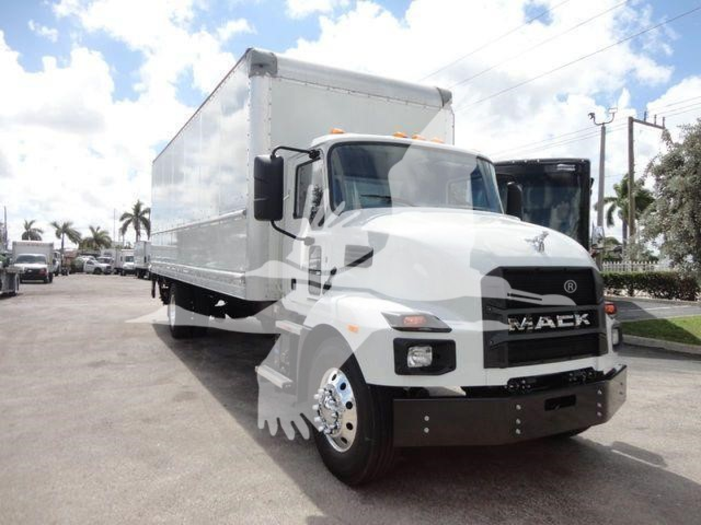 MD6 box truck showing Mack logo on grille and large cargo box with cab in front view. Clear sky and dealership lot in background.