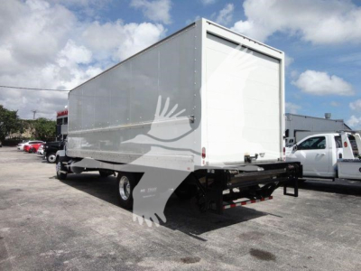 Back view of a new 2026 Mack MD6 box truck with a large white cargo box and black rear bumper. Stock number MACKMD6BOX26 visible in listing context.