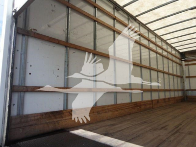 Box truck interior wall of a 2026 Mack MD6 in-service with wooden rails and metallic side panels.