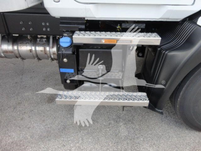 Truck steps and fuel tank area of a 2026 Mack MD6 with side steps and diesel exhaust system visible. Includes metal diamond-plate steps and a blue fuel cap.
