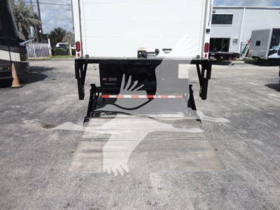 Box truck rear with ramp/ loading dock and hydraulic assembly visible under box on MACK MD6 stock unit, tail area and rear chassis components in view.