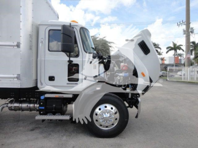 Tractor truck cab in side view with hood open showing engine bay. Visible text includes none legible on image beyond truck type.