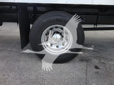 Mack MD6 wheel and tire assembly visible under truck, chrome hubcap, black chassis, in-service ground surface.