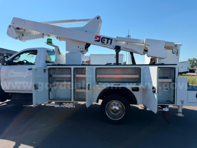 Truck-mounted bucket lift utility work truck with white body and elevated boom labeled GTI on the side.
