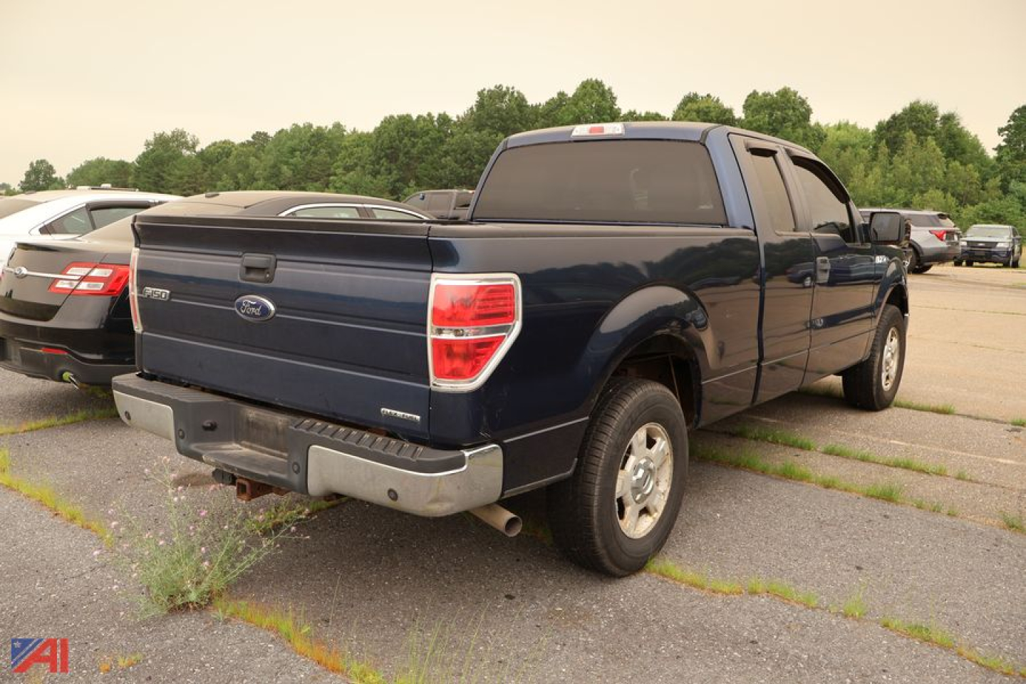 Ford F-150 extended cab pickup truck rear three-quarter view showing blue body, crew cab, and tailgate with Ford emblem.