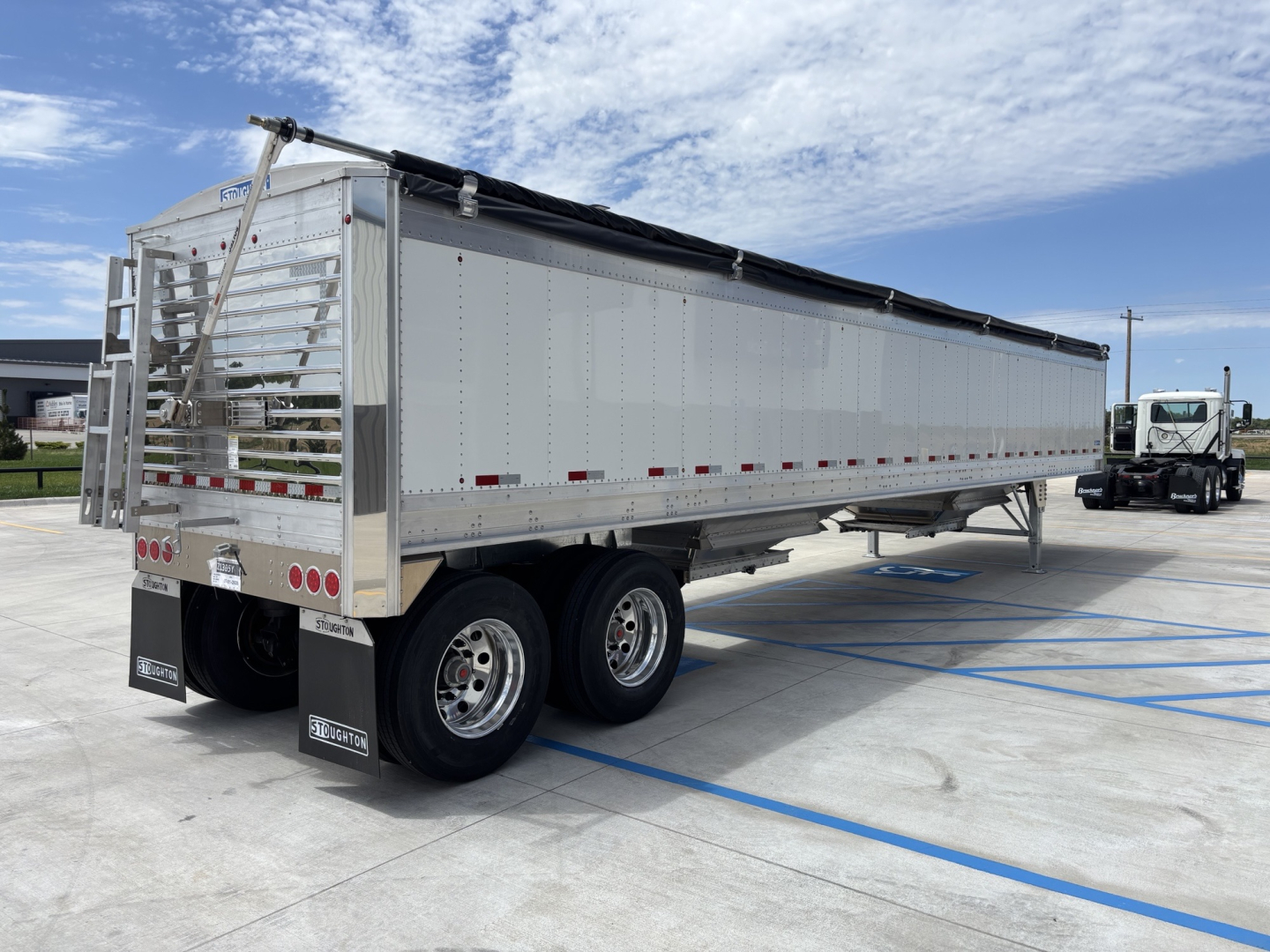 Trailer side view showing 42-foot aluminum grain hopper with 68-inch sides, tandem axles, tarp system, and rear ladders.
