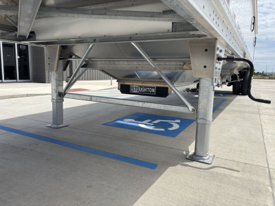 Aluminum grain hopper trailer underside showing support legs and Stoughton tag, 42' length with 68" side walls.