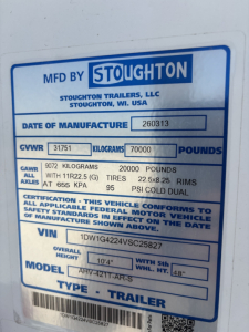 Stoughton trailer data plate showing MFD BY STOUGHTON with GVWR 31751 kg (70000 lb), GAWR 9072 kg (20000 lb) all axles, tire size 22.5x8.25 RIMS, VIN 1DW1G4224VSC25827, model AHV-421T-AR-S, date of manufacture 260313.