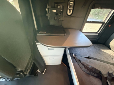 Kenworth T680 cab interior showing fold-down desk/table and storage drawers with window and seating area