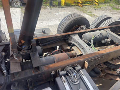 Truck chassis and drivetrain of a 2016 Kenworth T880 dump truck showing frame rails, differential, and air filter canister with visible wiring and components.