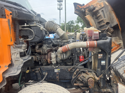 Kenworth T880 engine bay showing various hoses, radiator, and components in the engine compartment of a dump truck.