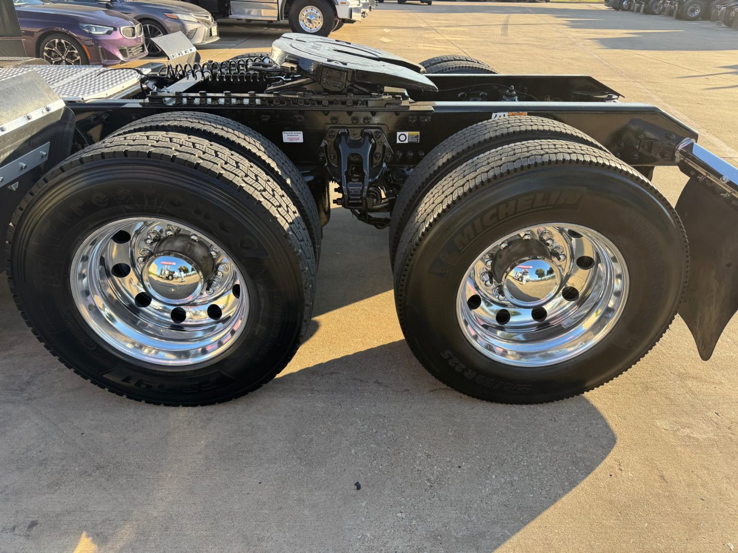 Kenworth T680 chassis showing dual rear wheels and chrome wheels, view of drive axles and frame, no cab visible.