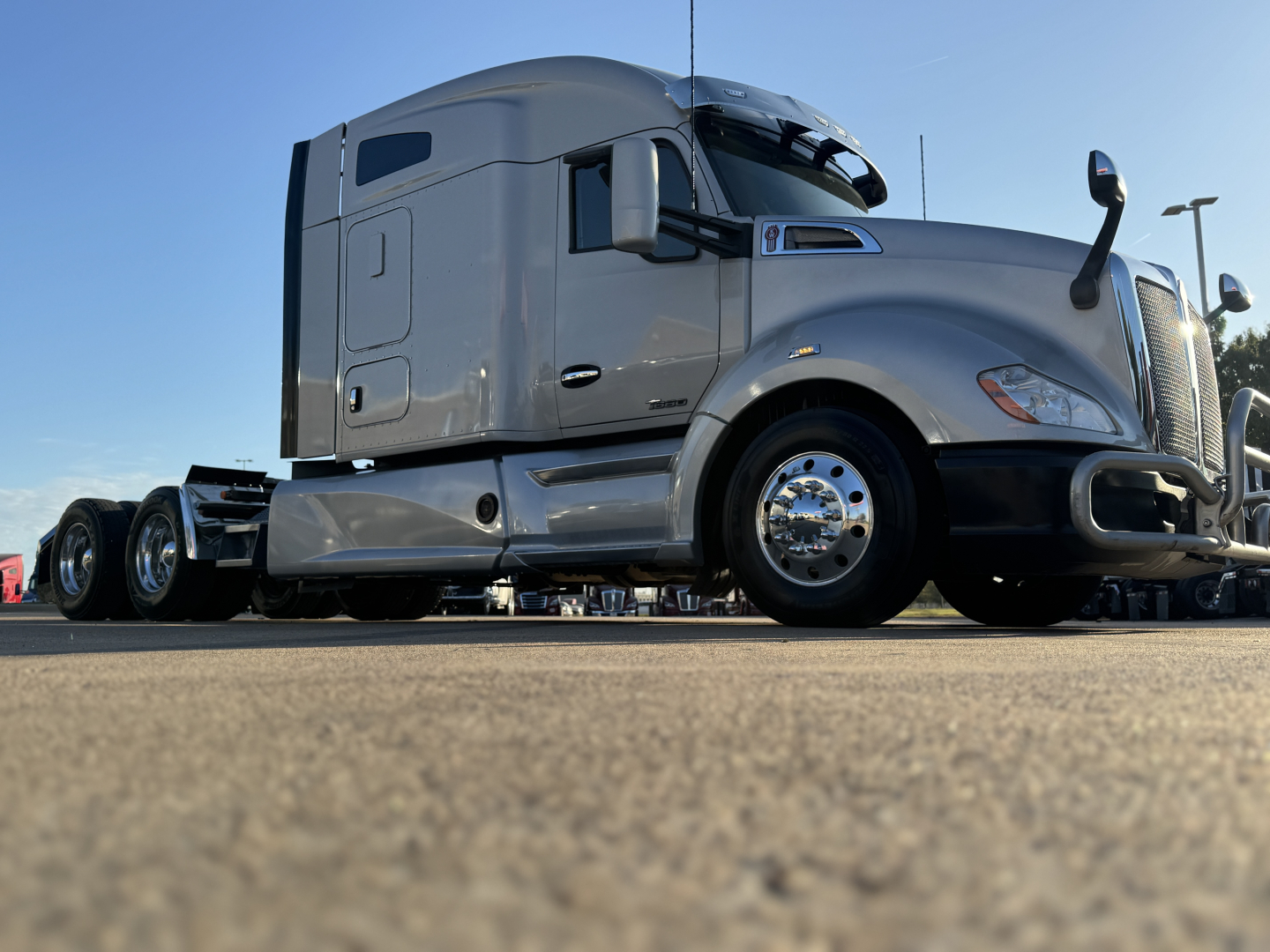 Kenworth T680 truck side view showing sleeper cab and front wheel, no visible text on components.