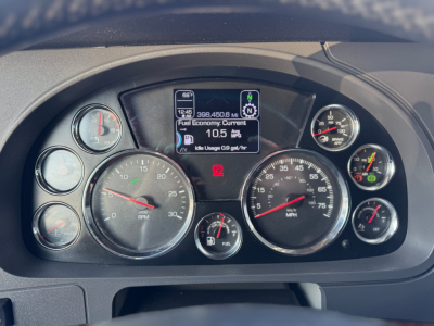 Kenworth T680 dashboard showing multiple round gauges, center digital display, and fuel economy readout.