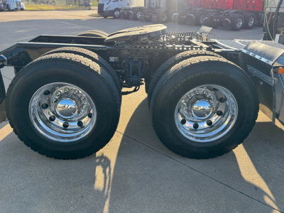Kenworth truck tandem rear wheels showing dual axle with chrome wheels and rugged tires.