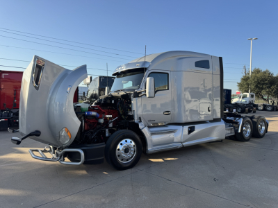 Kenworth T680 in-service truck cab with hood open, showing engine compartment; side view with sleeper cab and chrome wheels.