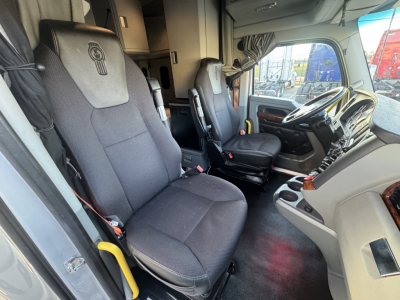 Kenworth T680 truck interior cabin view showing driver and passenger seats, dashboard, and steering wheel.