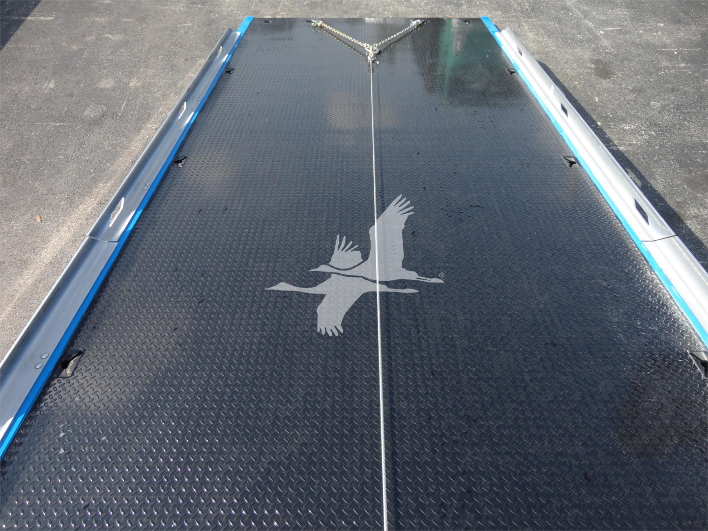 Truck bed with diamond plate surface and a white eagle decal, viewed from above.