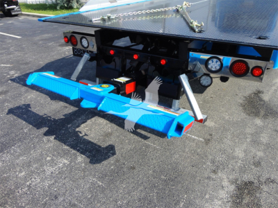 Blue underride protection bar attached to rear of 2022 Peterbilt 337 rollback truck with platform and safety lights.