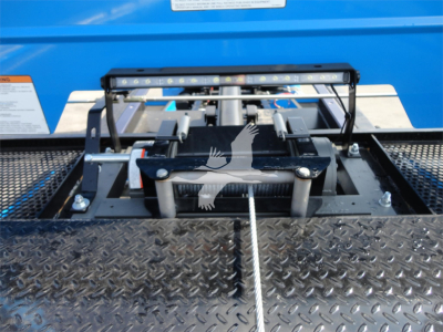 Truck hitch mechanism on blue Peterbilt 337 rollback unit with diamond plate platform and guide rails.