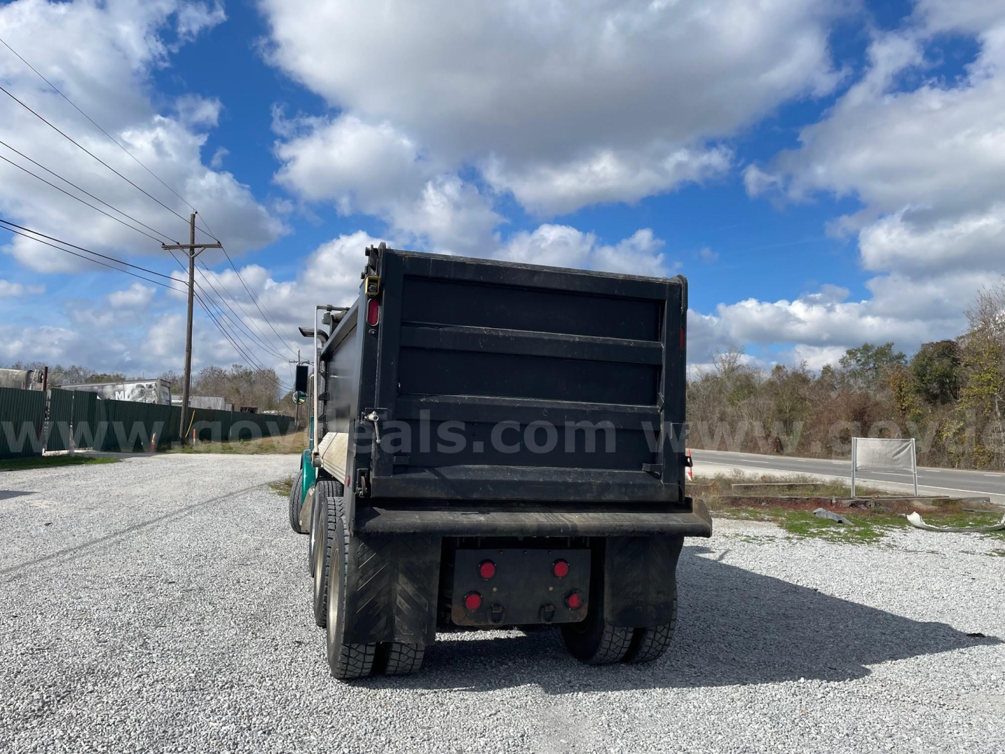 Peterbilt dump truck rear view showing dump bed and dual rear tires.