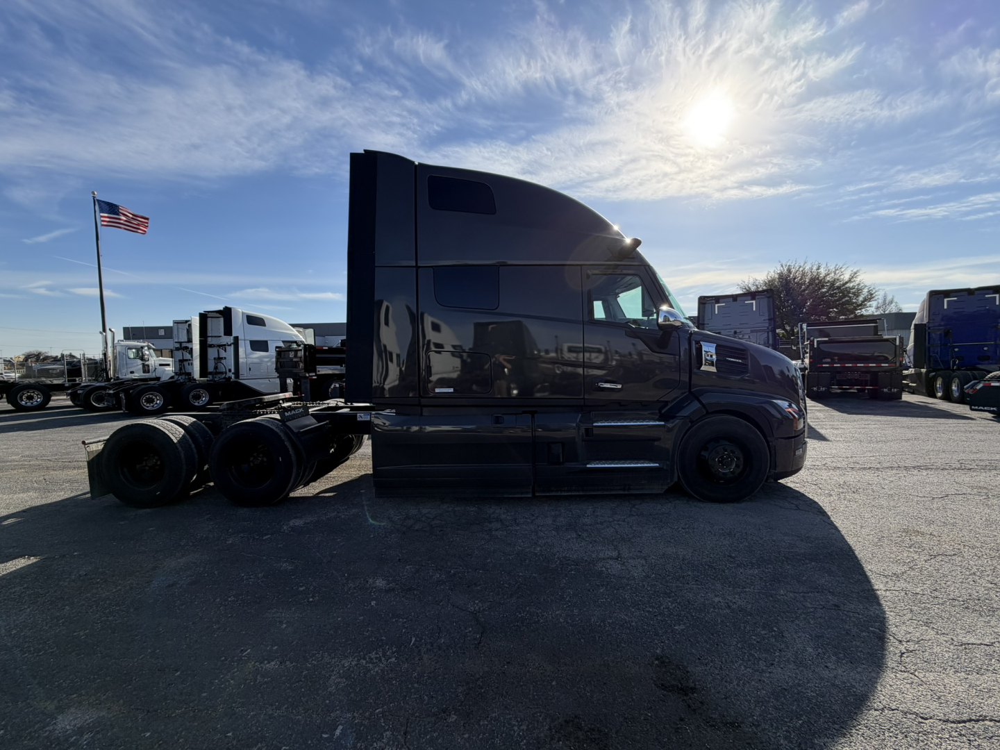 Mack PR64T76H sleeper tractor in profile view with black exterior and dual rear axles, VIN visible in listing context.
