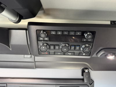 Dashboard control panel of a 2026 Mack PR64T76H truck showing radio/media controls and climate dials in a sleeper cab.