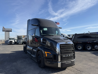 Mack PR64T76H conventional sleeper truck from front-left view showing black exterior, large grille, aerodynamic mirrors, and amber front turn signals.