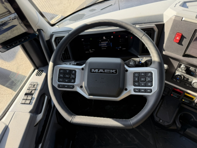 Steering wheel and dashboard of a new 2026 Mack PR64T76H truck cab interior showing Mack logo on steering wheel and control buttons.