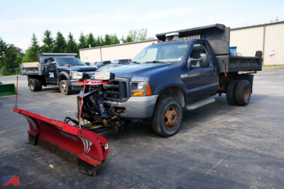 1995-2010 Ford F-350 XL SD dump truck with snow plow attachment and dual rear wheels, blue cab, black dump bed, red plow in front.