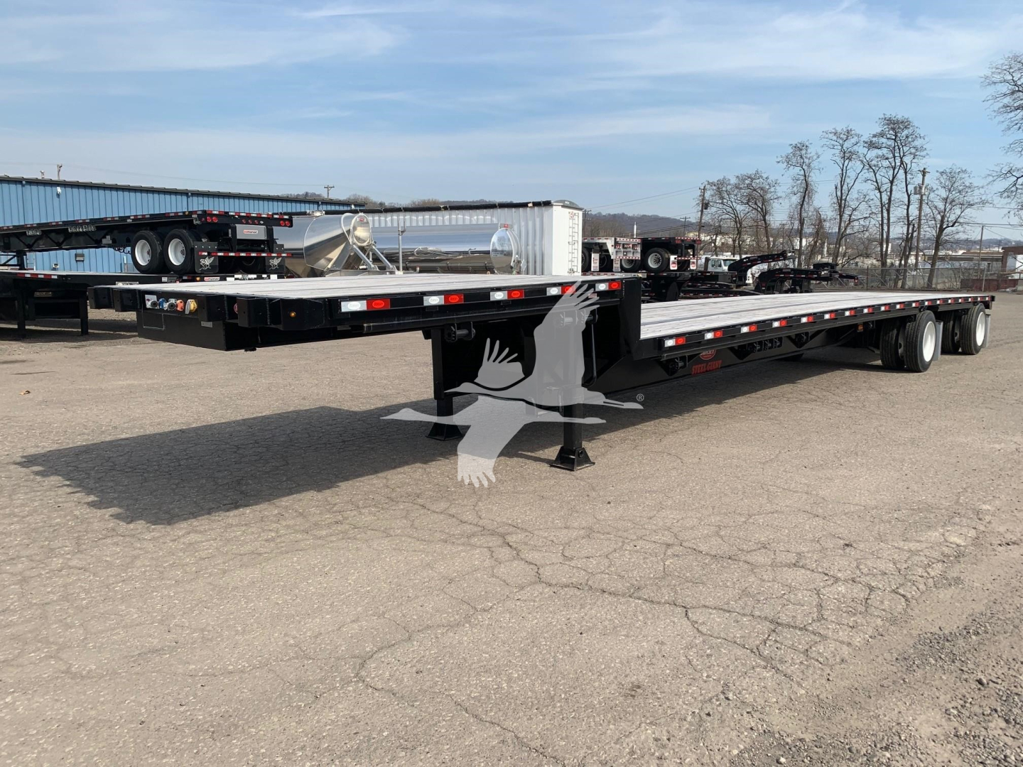 Trailer showing a long flatbed dropdeck with dual rear axles and landing gear. Visible text on stickers near the front shows VIN 7KYDF4829LED19283 and stock number 48-5983.