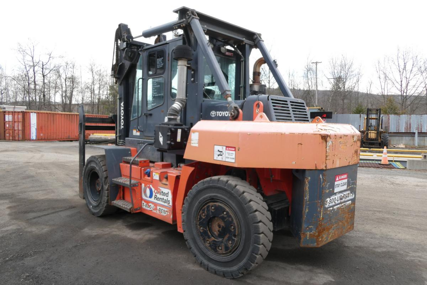 Truck-mounted forklift 2018 Toyota THD3000-24 in serviceable condition showing cab, orange counterweight, and forklift mast in a yard.