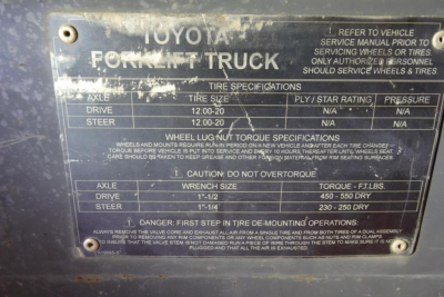 Toyota forklift truck data plate showing axle, drive, steer, tire specifications and torque; includes warnings and numbers such as 12.00-20 tire size, 1-1/2 inch wrench size, 450-550 ft-lbs torque, 230-250 dry? in fuel