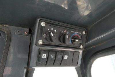 Control panel with climate knobs and switches in a Toyota THD3000-24 forklift cab showing HVAC dials and button row.