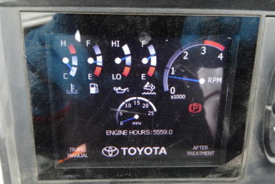 Dashboard display showing Toyota engine gauges with RPM gauge up to 4 (x1000), temperature gauges, and engine hours 5559.0; Toyota logo and text 'TOYOTA' 'AFTER TREATMENT' visible.
