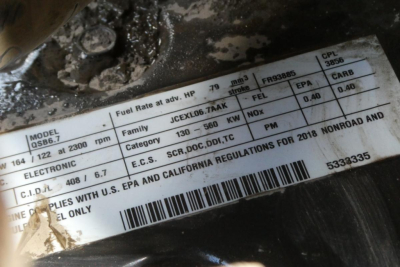 Label on machinery showing model info, fuel rate, HP, rpm, serial numbers, and regulatory stamps. Text includes fuel rate at adv. HP 79, rpm 2300, 130-560kW, 1100, EPA, California regs, E.E.C.S. etc.