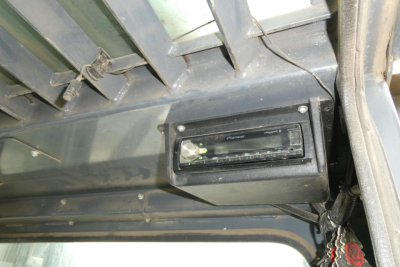 Truck lifting equipment cabin interior showing Pioneer stereo head unit and control panel in dashboard area with wiring nearby.