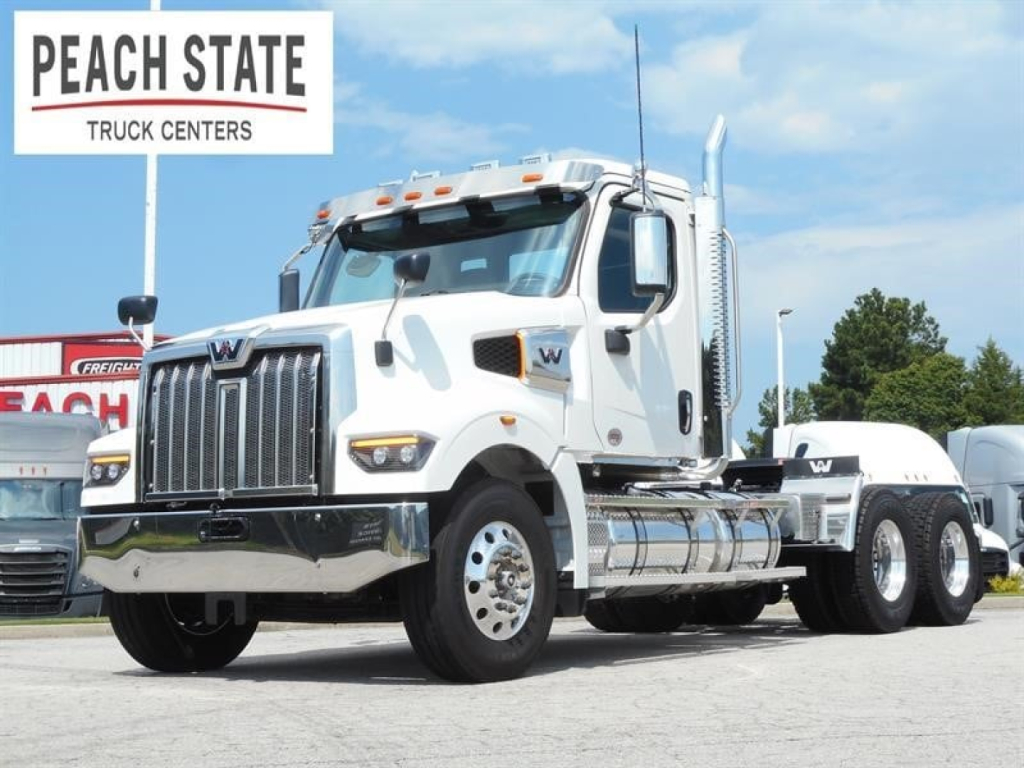 White Western Star 49X heavy-duty truck in service bay, front grille and chrome bumper, Peach State Truck Centers logo visible.