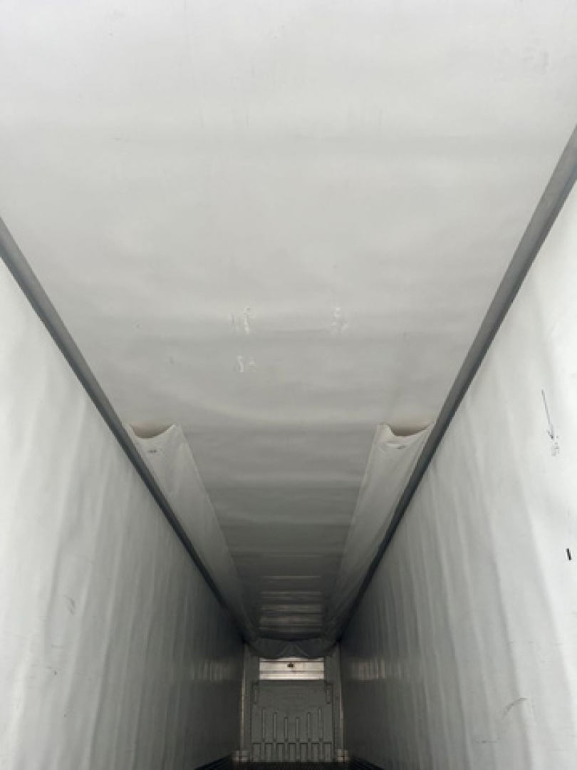 Trailer interior showing a long refrigerated cargo area with white walls and ceiling, painted metal floor, no visible labels or text inside.