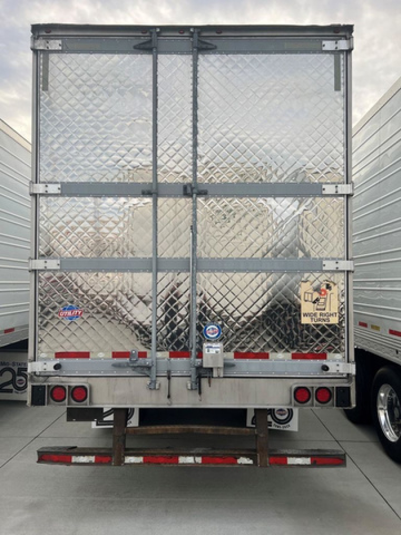 Refrigerated trailer rear view with diamond plate aluminum doors and dual rear lights. Appears used; stock U91140 with side door latches and warning stickers visible.