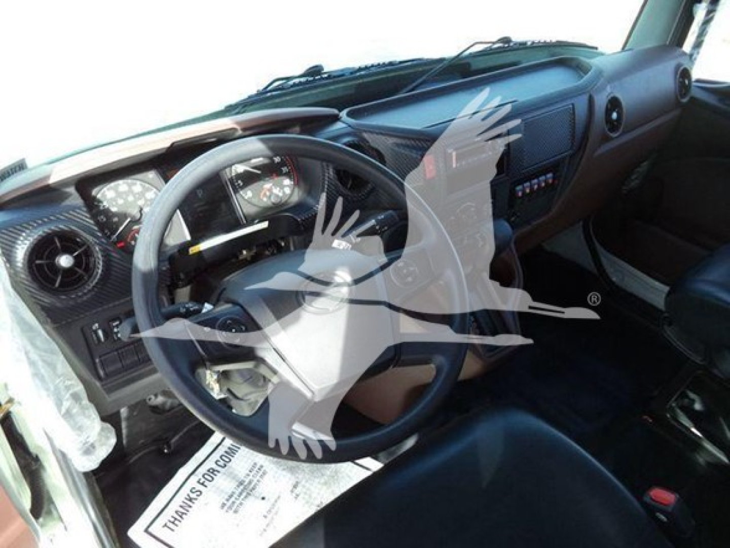 Interior of a 2025 Hino 268A cab showing steering wheel dashboard and driver seat with dashboard controls.
