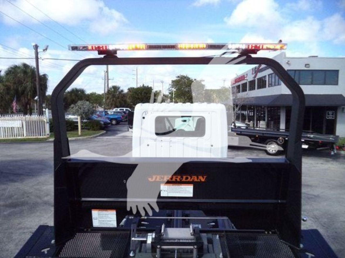 Truck rollback frame with Jerr-Dan body showing rear view, cab, and light bar.
