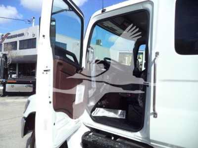 vehicle cab interior of a 2025 Hino 268A rollback truck showing open door, interior seat and control area.