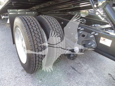 Truck chassis and dual rear tires under a Hino 268A dump truck showing axle and frame components.