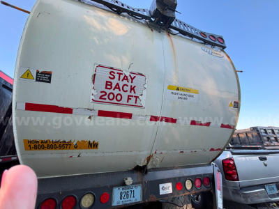 Rear view of a white Peterbilt COE fuel/tank truck showing 'STAY BACK 200 FT' warning, caution labels, and license plate Indiana 82671.