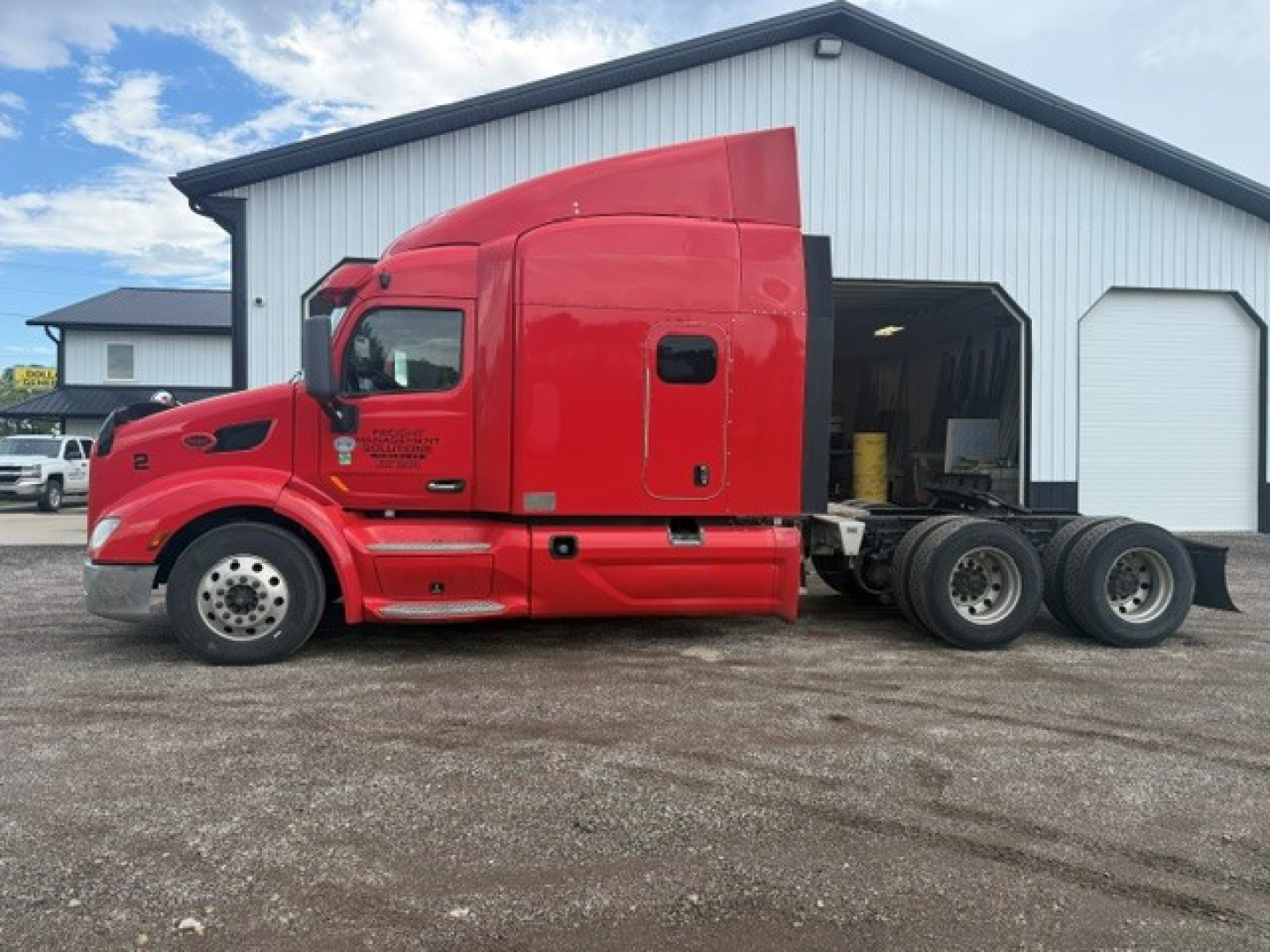 Peterbilt 579 tractor unit side view showing red cab and mid-section, 6x4 configuration with sleeper, rear wheels and chassis visible.
