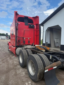 Peterbilt 579 tractor in-service rear view showing sleeper cab, tandem rear axles, and fifth-wheel connection.